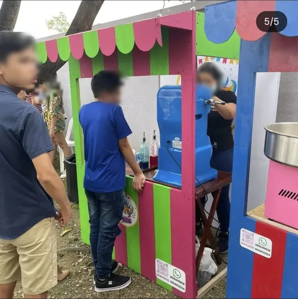 Puesto de granizados y algodón de azúcar de Chewie Eventos atendido durante una fiesta al aire libre